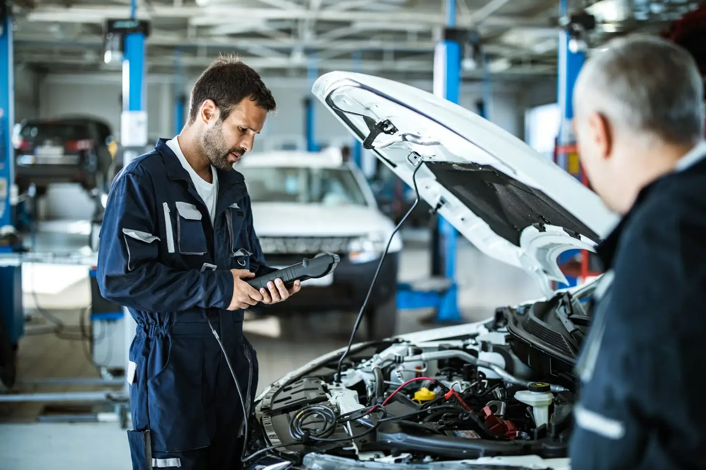 Technician running computer diagnostics on a vehicle in the service bay